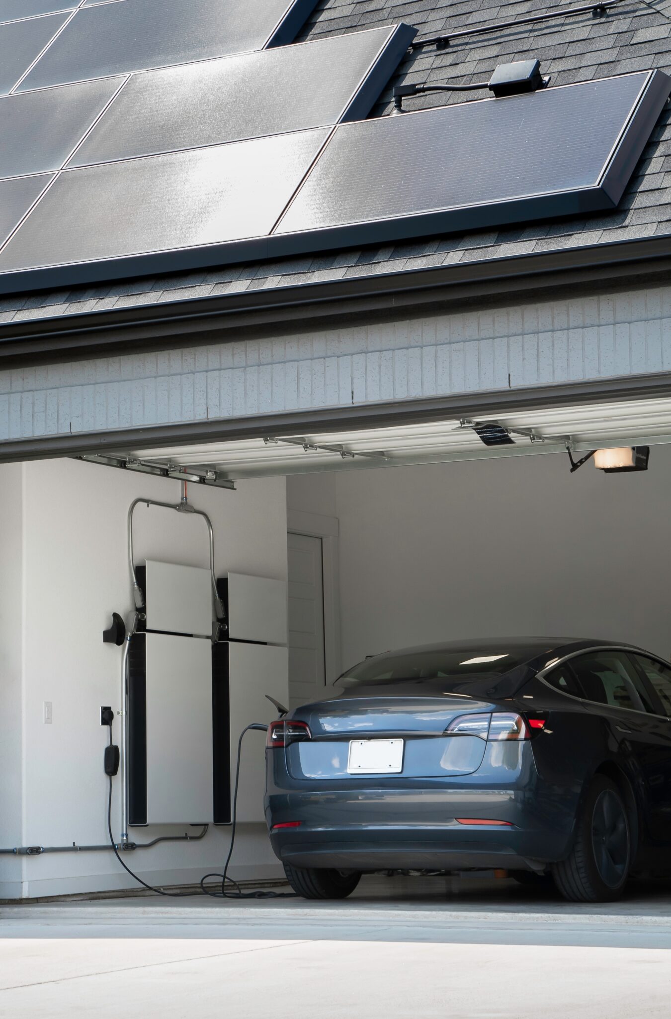 An electric vehicle being charged using an outdoor EV charger enclosure.